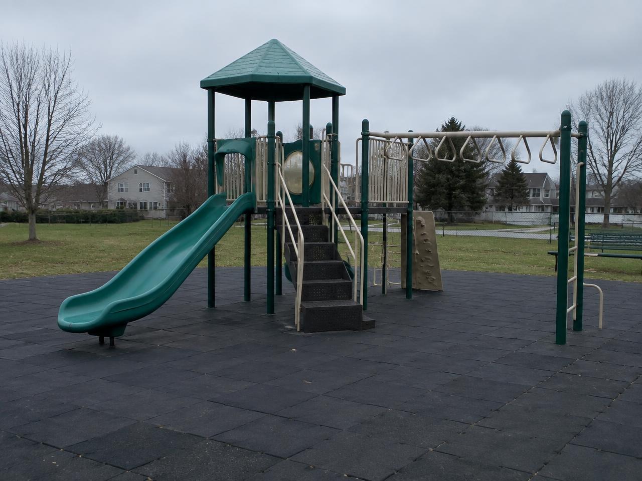 A plain, generic suburban play structure on a grey day